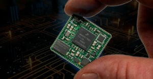 Stylized photo of a SOMRT1061 System-On-Module held between two fingers