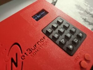 Closeup of the SOMRT1061 Dev Kit running the example program on a Qwiic OLED Display, with a keypad and 3D printed case